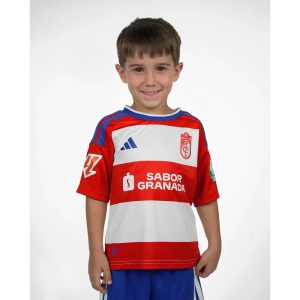 Primera equipación del Granada CF para niños temporada 2026-27. Conjunto oficial de camiseta y pantalón para los más pequeños.